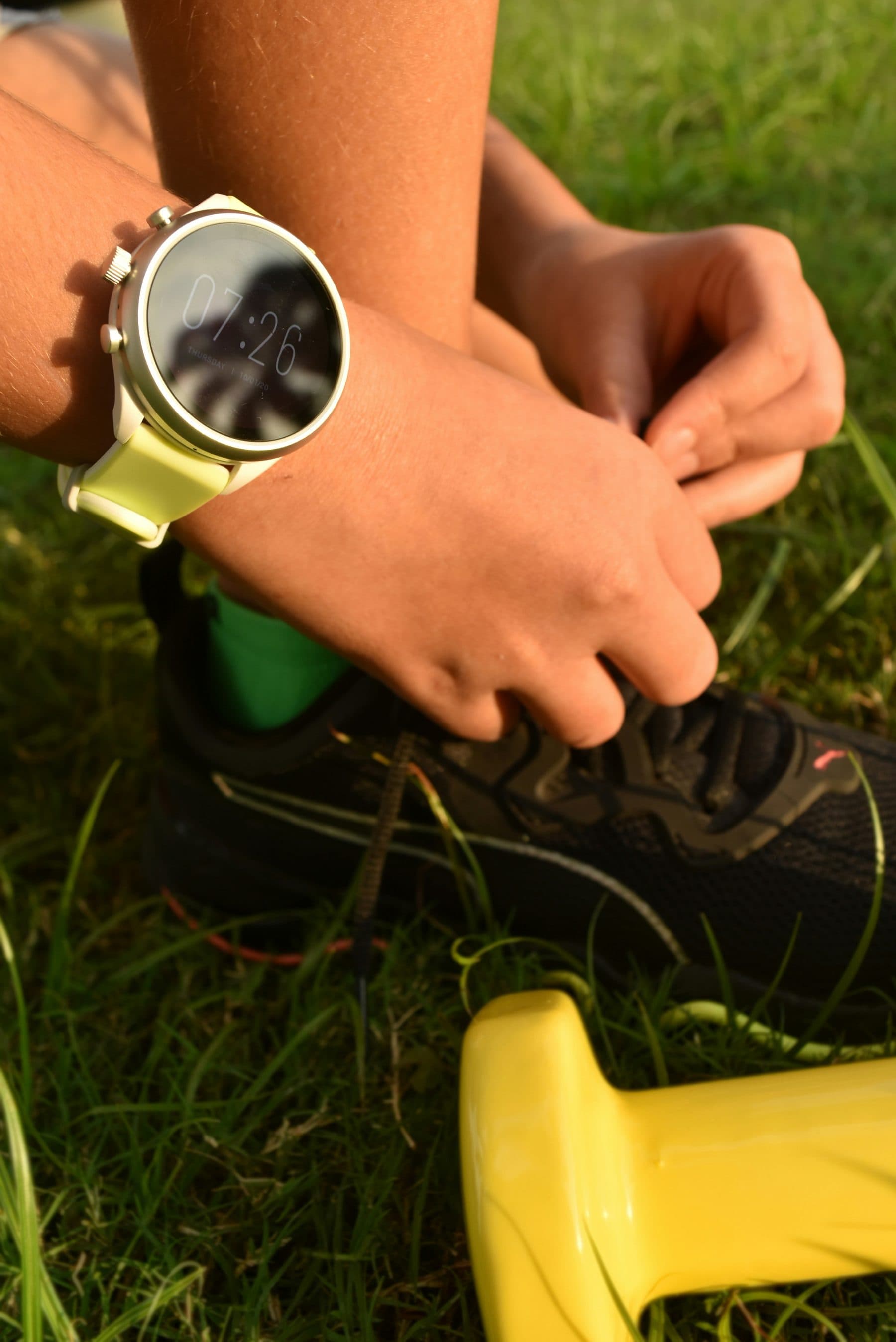 Corredor atándose las zapatillas con su reloj deportivo en la muñeca